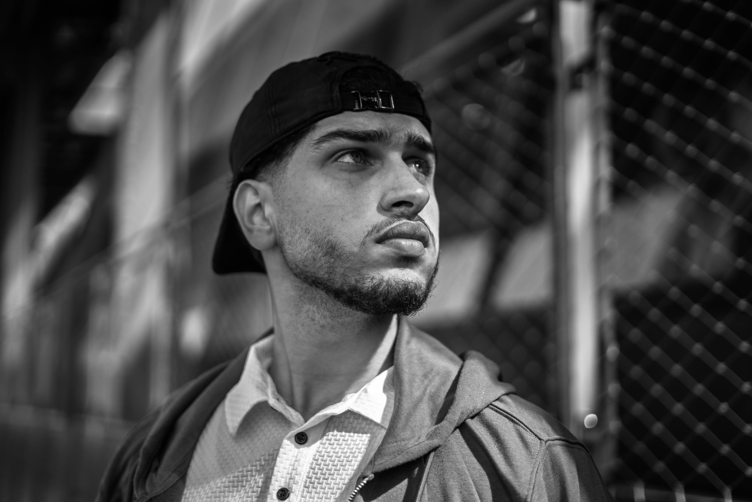 Portrait en noir et blanc, casquette à l’envers, regard levé