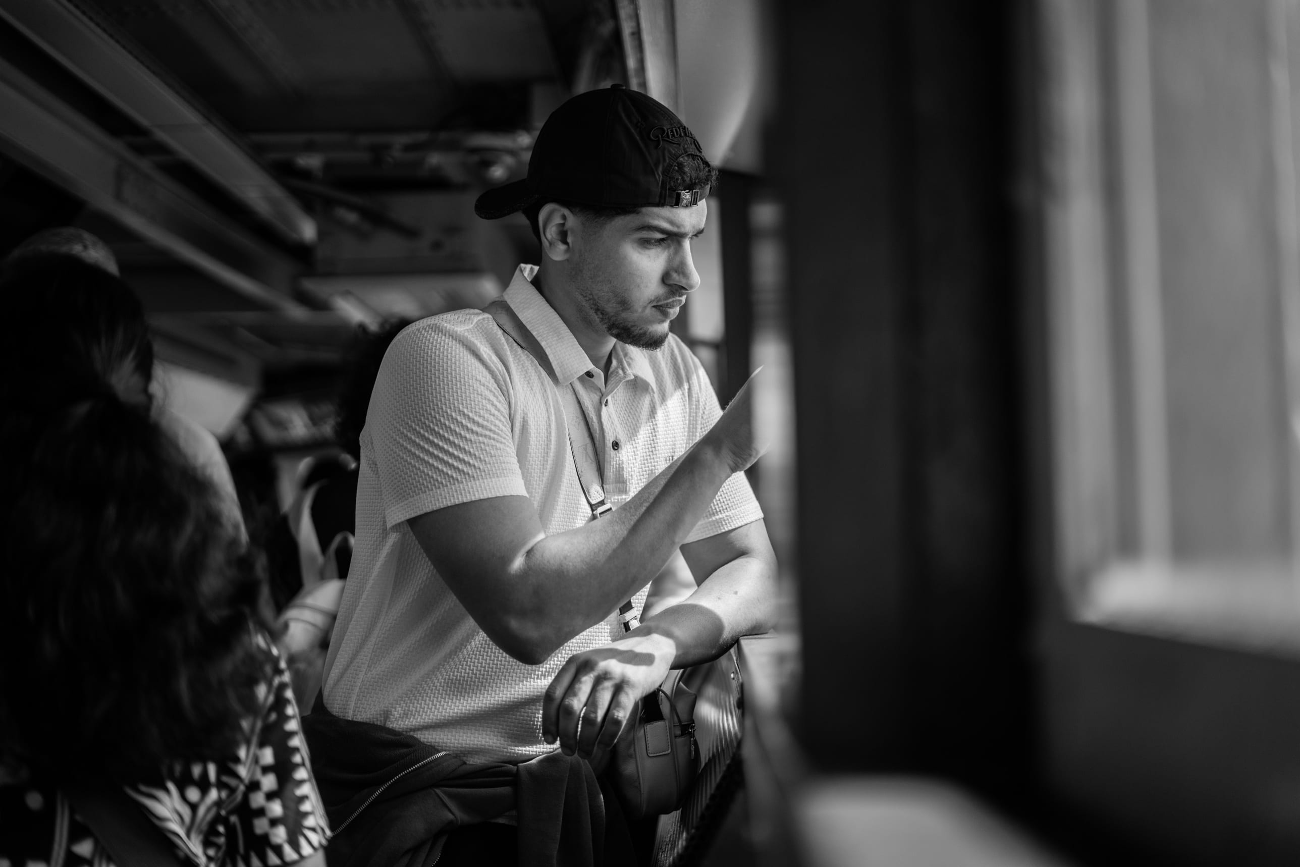Portrait en noir et blanc, accoudé à une rambarde, regard baissé