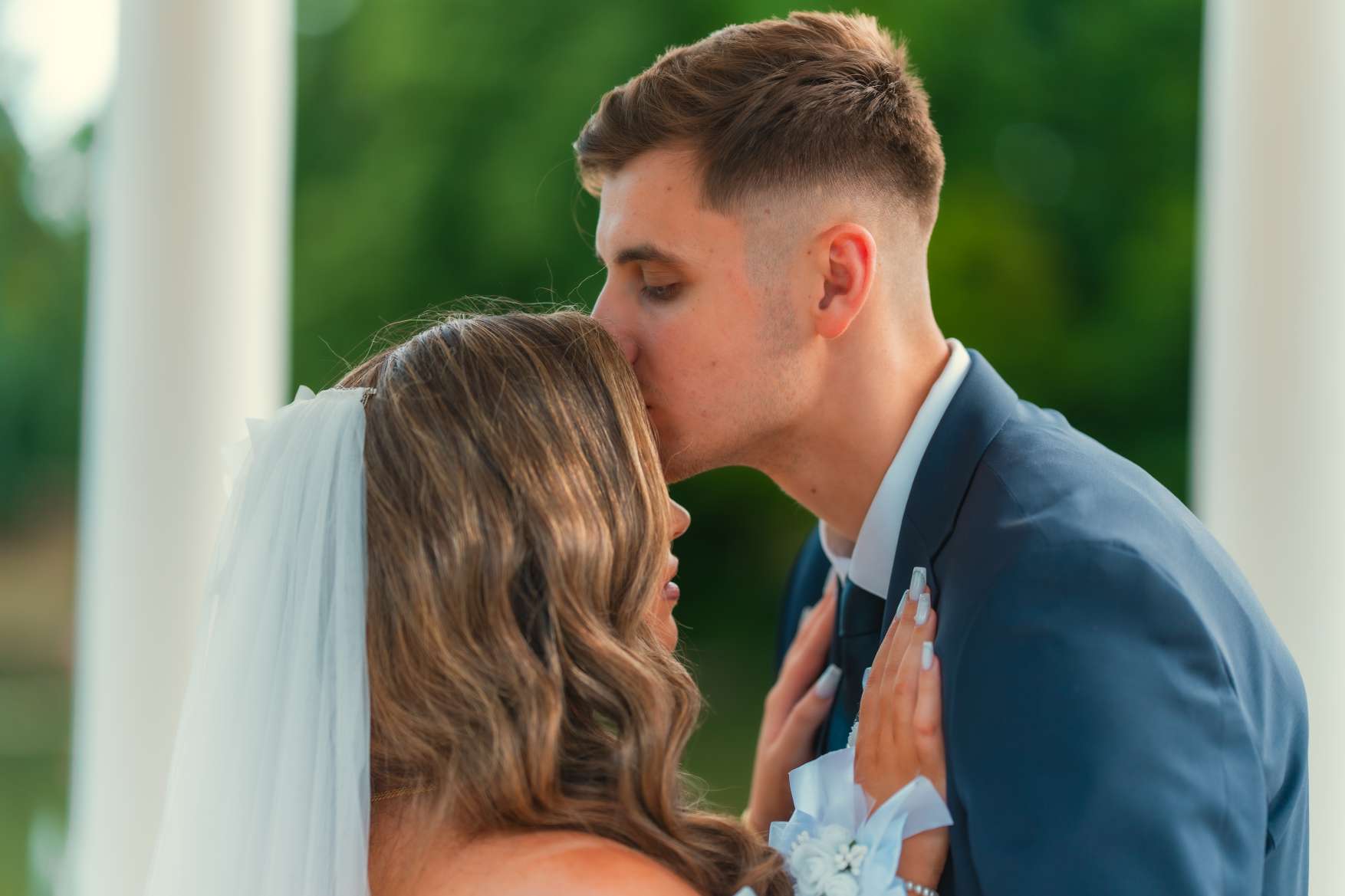 Le marié embrasse la mariée sur le front